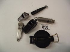 A quantity of whistles, a cigar cutter and an engineers directional compass