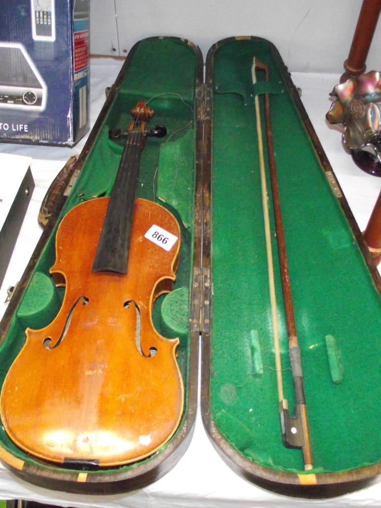 An old violin in wooden case with bow.