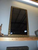 A gilt framed bevel edged mirror.