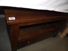 A heavy dark oak coffee table with drawer