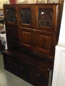 A dark oak wall unit sideboard with leaded glass doors