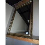 A qilt framed, bevel edge mirror. 61cm x 87cm.