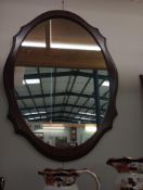 A darkwood stained oval mirror