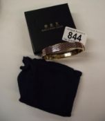 A Halcyon Days Salamander bangle in navy and gold in original box