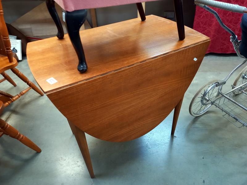 A vintage teak oval drop leaf dining table on tapered octagonal legs