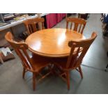 A set of 4 pine kitchen chairs and a round dining table, top is loose and needs replacement screws