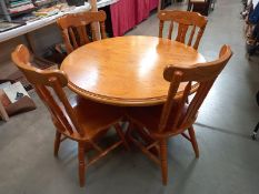 A set of 4 pine kitchen chairs and a round dining table, top is loose and needs replacement screws