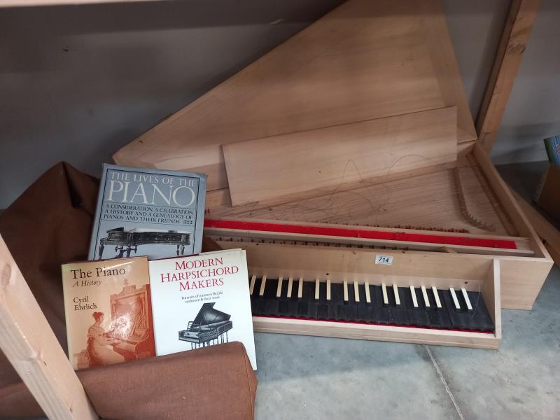 A wooden harpsichord, case and three books. Collect Only. Harpsichord in the case needs attention,