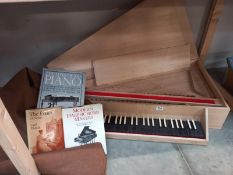 A wooden harpsichord, case and three books. Collect Only. Harpsichord in the case needs attention,