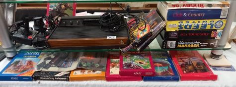 A vintage Atari wood grain games console and selection of games and controls