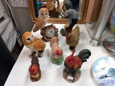 A mixed lot of cockerel and owl figures, plus a grey parrot