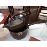 A Victorian copper saucepan with iron handle and vintage brass watering can.