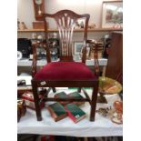 A mahogany carver chair with red velvet seat