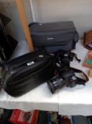 A Sony camera and Minolta camera both in carry cases etc