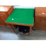 A vintage green felt covered folding card table