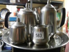 A stainless steel tea set on tray.