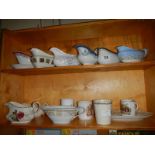 Two shelves of gravy jugs etc.,