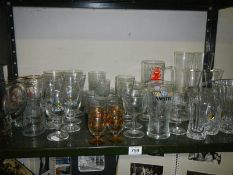 A shelf of drinking glasses including advertising, COLLECT ONLY.