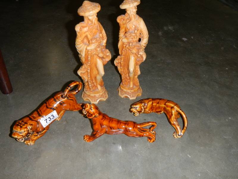 A pair of Chinese figures and three tigers.