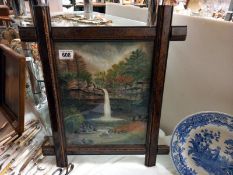 An oak framed picture of a waterfall.