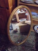 An oval framed bevel edged mirror. COLLECT ONLY.