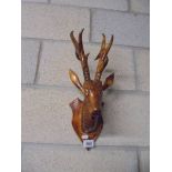 A wooden wall hanging stags head.