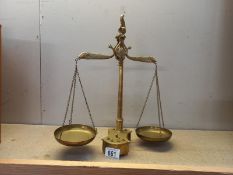 A set of solid brass balance scales and weights with fish decoration