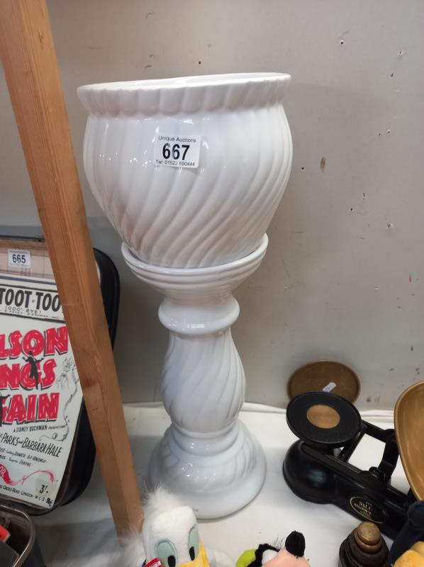 A white pottery jardiniere on stand