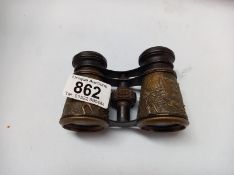 A pair of vintage opera glasses with relief brass hunting scenes