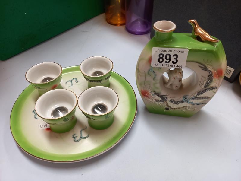 A Japanese SAKI moon flask with 4 cups with magnifying bottoms on tray
