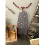 A vintage ironing board with flamingo bird cover