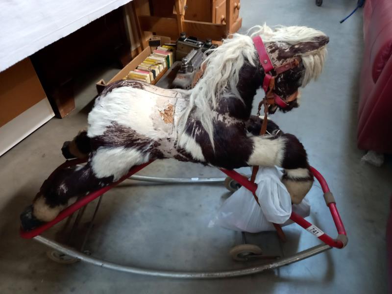 A vintage straw filled rocking horse on folding wheels
