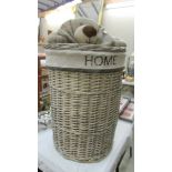 A wicker linen basket with soft toy dog lid, 46 cm diameter x 74 cm high.