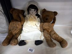 Two vintage teddy bears and a doll.