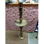 A large Indian brass Church candlestick with wax collection drip tray
