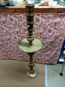 A large Indian brass Church candlestick with wax collection drip tray