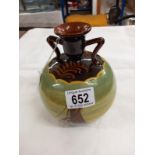 An attractive round bulbous vase or candle holder with two shoulders. Brown with paintings of yachts