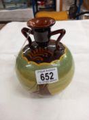 An attractive round bulbous vase or candle holder with two shoulders. Brown with paintings of yachts