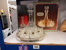 A boxed crystal decanter with 6 glasses & a tray
