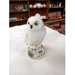 A Crown Staffordshire fine bone china snowy owl on a pine tree log. Signed M.R.T with a K