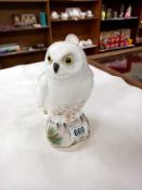 A Crown Staffordshire fine bone china snowy owl on a pine tree log. Signed M.R.T with a K