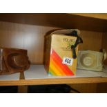An old Polaroid camera and two other camera's.
