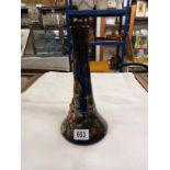 An 11" high Longpark vase with a wide base and narrower neck. Applied flowers and leaves on a