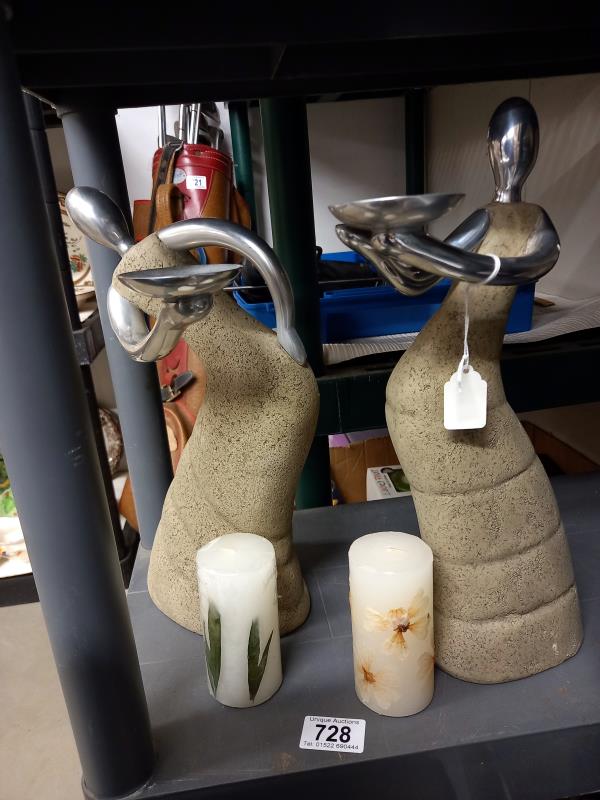 A pair of contemporary figural candle holders.