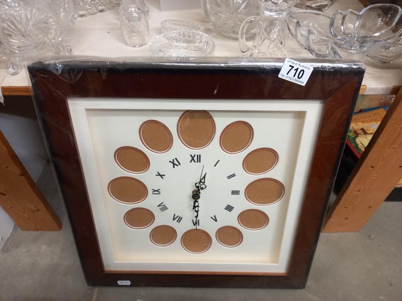 A battery operated clock with 12 spaces for photos.