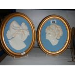 A pair of oval plaster portrait plaques.