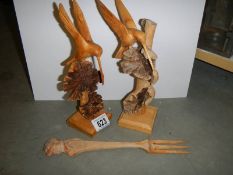 Two carved wood birds and a carved wood fork.