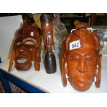 Three carved wood tribal figures.