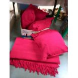 4 red cushions and a matching red throw