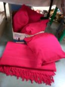 4 red cushions and a matching red throw